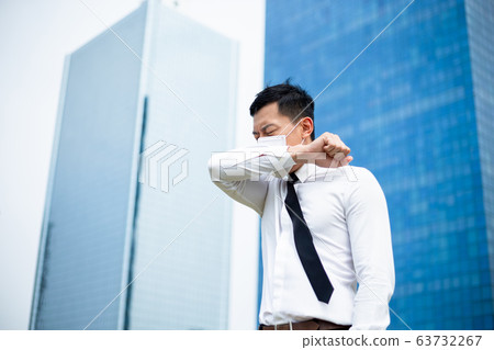 Asian man cough in elbow 63732267