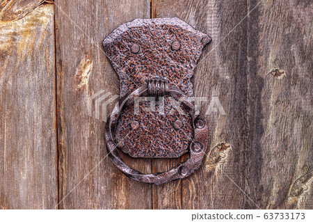 Iron doorknob on an old wooden door Iron doorknob on an old wooden door 63733173
