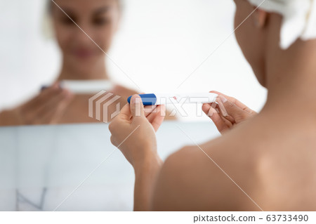 Woman hands holding pregnancy test with two red stripes result Woman hands holding pregnancy test with two red stripes result 63733490