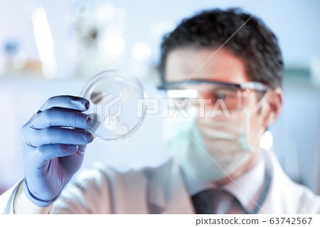 Scientist working in corona virus vaccine development laboratory research facility. Scientist working in corona virus vaccine development laboratory research facility. 63742567