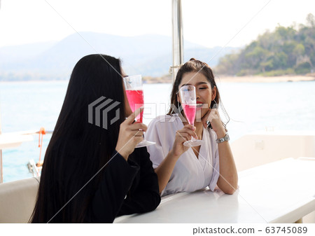 Beautiful two asia woman traveling for relaxation and drinking wine on speed boat at Thailand. Beautiful two asia woman traveling for relaxation and drinking wine on speed boat at Thailand. 63745089