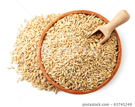 Barley grains in a wooden plate with a spatula. Barley grains in a wooden plate with a spatula. 63745249