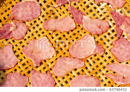 Top view picture of closeup many pieces of pork in the bamboo basket dry by the light of sun Top view picture of closeup many pieces of pork in the bamboo basket dry by the light of sun 63746432
