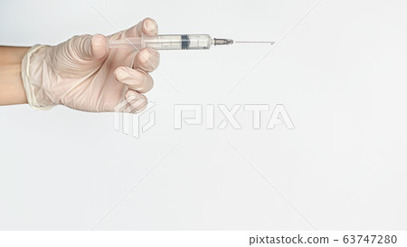 Hand in medical glove with syringe. Close up. For medical publications, immunization and vaccination campaign of people against infection and bacterial disease 63747280