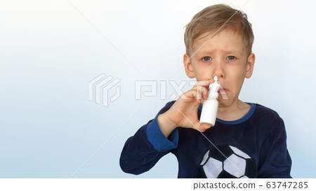 Child boy spraying medicine in nose against flu. Self-medicating, nose spray, health and care concept. 63747285