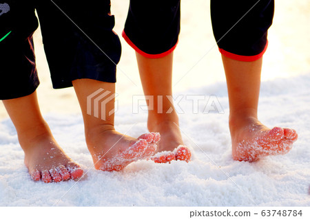 A child walking barefoot in a salt field at the salt-filled experience in Sorae Wetland Ecological Park, Incheon 63748784