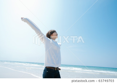 A woman stretching at the beach 63749703