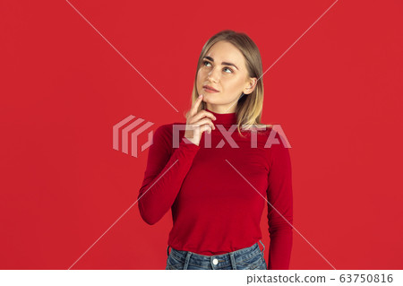 Monochrome portrait of young caucasian blonde woman on red background 63750816