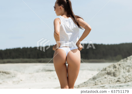 Crop woman with firm buttocks on beach 63751179