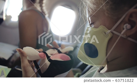 Little girl caucasian at plane with wearing protective mask. Child baby tourist at aircraft with respirator play and paint. Covid-19. Little girl caucasian at plane with wearing protective mask. Child baby tourist at aircraft with respirator play and paint. Covid-19. 63751822