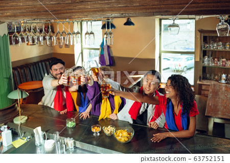 Sport fans cheering at bar, pub and drinking beer while championship, competition is going Sport fans cheering at bar, pub and drinking beer while championship, competition is going 63752151