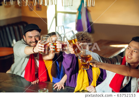 Sport fans cheering at bar, pub and drinking beer while championship, competition is going Sport fans cheering at bar, pub and drinking beer while championship, competition is going 63752153