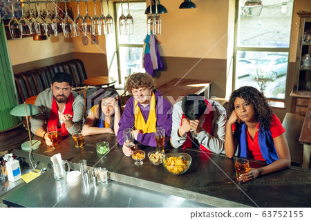 Sport fans cheering at bar, pub and drinking beer while championship, competition is going 63752155
