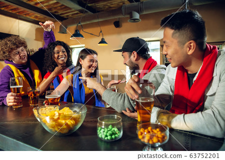 Sport fans cheering at bar, pub and drinking beer while championship, competition is going 63752201