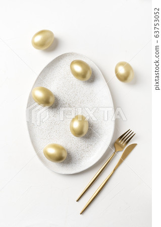 Easter table setting with bunny and golden eggs  63753052