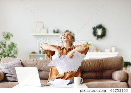 Happy elderly freelancer throwing papers. 63753103