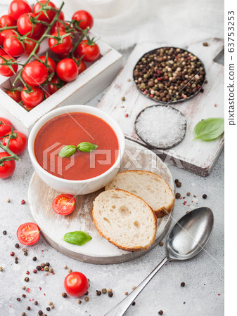 White bowl plate of creamy tomato soup with spoon 63753253