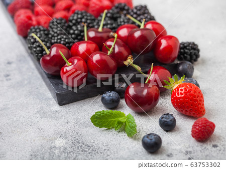 Fresh organic summer berries mix on black marble 63753302