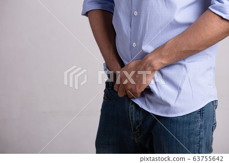 A young man suffering from prostatitis or from a 63755642