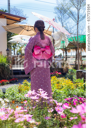 The girl is wearing a pink traditional yukata, which is the national dress of Japan and Hold an umbrella 63755984