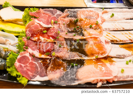 fresh slide bacon with beef pork and Shrimp, squid and mushrooms on tray ready to grill and cook on wood table in restaurant. Close up and select focus fresh slide bacon with beef pork and Shrimp, squid and mushrooms on tray ready to grill and cook on wood table in restaurant. Close up and select focus 63757210