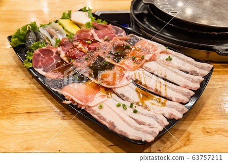 fresh slide bacon with beef pork and Shrimp, squid and mushrooms on tray ready to grill and cook on wood table in restaurant. Close up and select focus 63757211