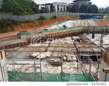 Building floor slab under construction. Construction workers fabricating the timber formwork and installing the steel reinforcement bar. Building floor slab under construction. Construction workers fabricating the timber formwork and installing the steel reinforcement bar. 63762401