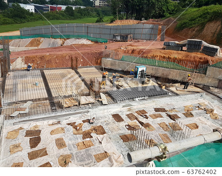 Building floor slab under construction. Construction workers fabricating the timber formwork and installing the steel reinforcement bar.  63762402