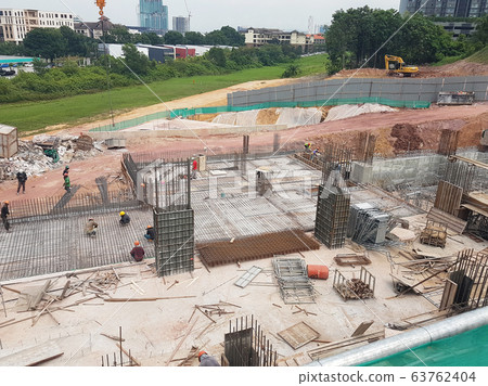 Building floor slab under construction. Construction workers fabricating the timber formwork and installing the steel reinforcement bar.  63762404