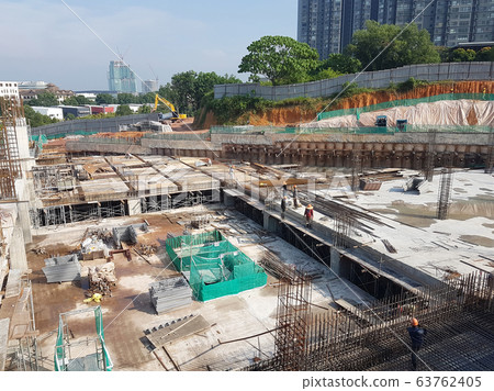 Building floor slab under construction. Construction workers fabricating the timber formwork and installing the steel reinforcement bar.  63762405