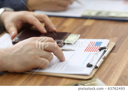 Male hands in suit lie on application for usa visa Male hands in suit lie on application for usa visa 63762493