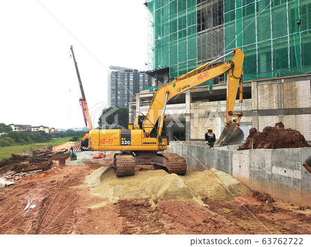Excavators machine at the construction site. It is used to excavate soil and lifting material at the construction site. Powered by the hydraulic arm with a bucket.   63762722