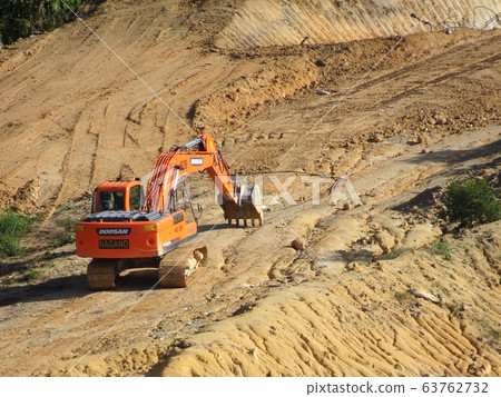 Excavators machine at the construction site. It is used to excavate soil and lifting material at the construction site. Powered by the hydraulic arm with a bucket. Excavators machine at the construction site. It is used to excavate soil and lifting material at the construction site. Powered by the hydraulic arm with a bucket. 63762732