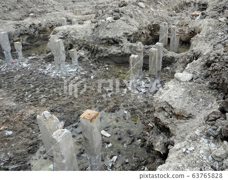 Square precast concrete pile at the construction site. Driven to soil using concrete pile machine. Square precast concrete pile at the construction site. Driven to soil using concrete pile machine. 63765828