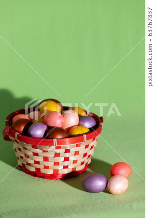 Easter eggs in basket isolated on green Easter eggs in basket isolated on green 63767837