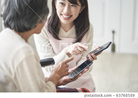 An elderly woman learning how to use a smartphone An elderly woman learning how to use a smartphone 63768589