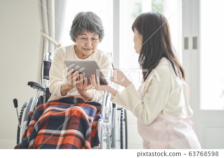 Elderly woman looking at tablet 63768598