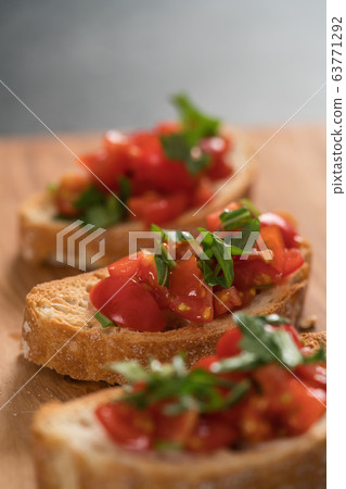 bruschetta with cherry tomatoes and spinach leaves on olive board 63771292