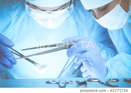 Close-up of medical team performing operation. Group of surgeons at work are busy of patient. Medicine, veterinary or healthcare concept Close-up of medical team performing operation. Group of surgeons at work are busy of patient. Medicine, veterinary or healthcare concept 63771734