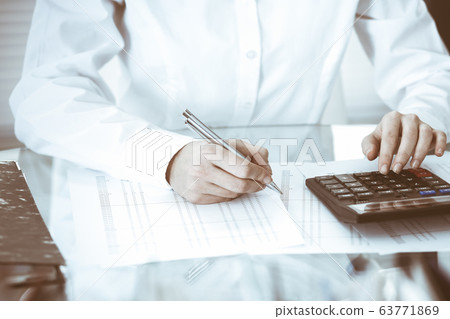 Bookkeeper woman or financial inspector making report, calculating or checking balance, close-up. Business, audit or tax concepts 63771869