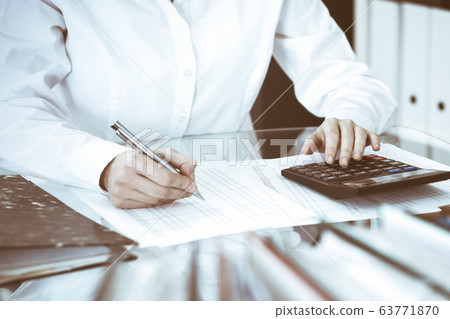 Bookkeeper woman or financial inspector making report, calculating or checking balance, close-up. Business, audit or tax concepts 63771870