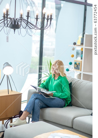 Blonde woman in a green blouse looking busy 63772454