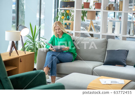 Blonde woman in a green blouse looking involved 63772455
