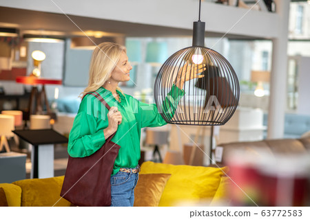 Blonde woman in a green blouse looking at the cage 63772583