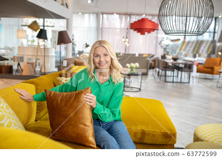 Blonde woman in a green blouse looking positive Blonde woman in a green blouse looking positive 63772599