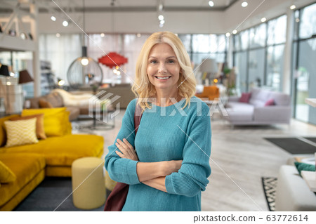 Blonde woman in a blue dress smiling nicely 63772614