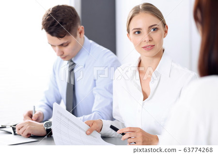 Group of business people or lawyers discussing terms of transaction in office. Colleagues working all together. Meeting concept Group of business people or lawyers discussing terms of transaction in office. Colleagues working all together. Meeting concept 63774268