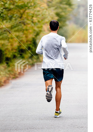 male runner running in autumn park male runner running in autumn park 63774426