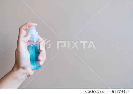 woman hand spraying alcohol sanitizer bottle woman hand spraying alcohol sanitizer bottle 63774464