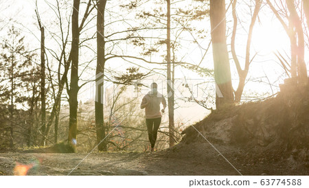 Corona virus, or Covid-19, is spreading all over the world. Portrait of caucasian sporty woman wearing a medical protection face mask while running in nature. 63774588
